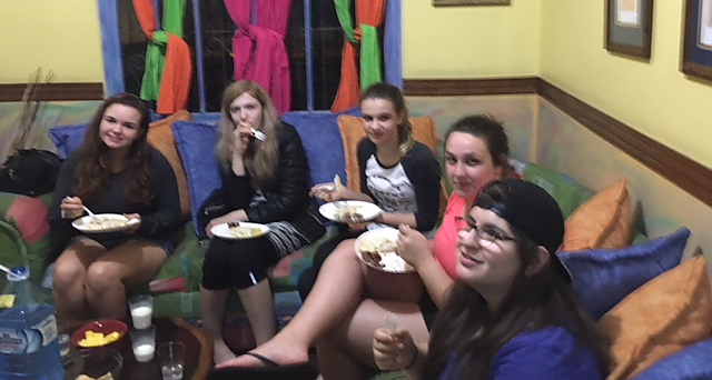 Photograph of students gathered and enjoying a Pasta Alfredo dinner