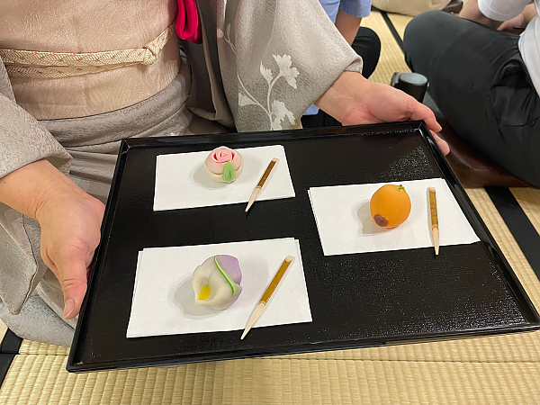 Tray with colorful tea ceremony treats on 3 different white plates
