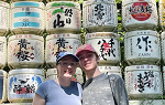 Two students posing for photo in front of colorful wall with Japanese lettering