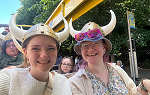 Two students smiling while wearing viking helmets