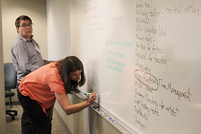 Participants in a LCIRT workshop working together on a whiteboard. 