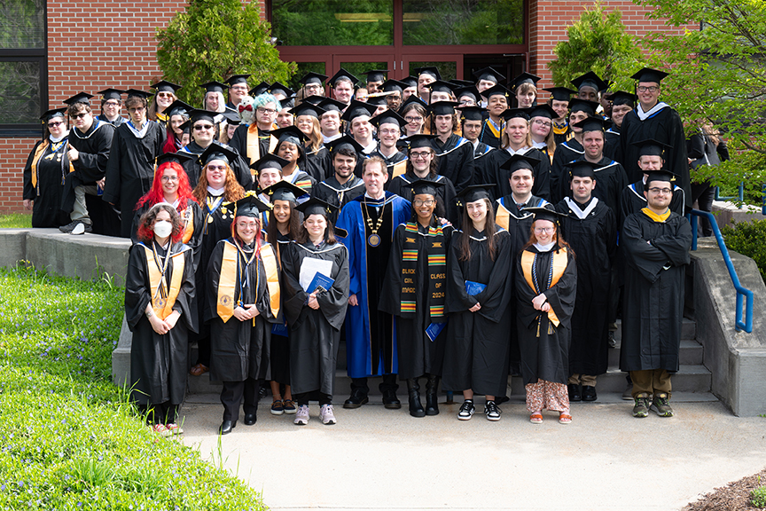 May 2024 graduating class photo outside the Click Center with LC President Dr. Peter Eden